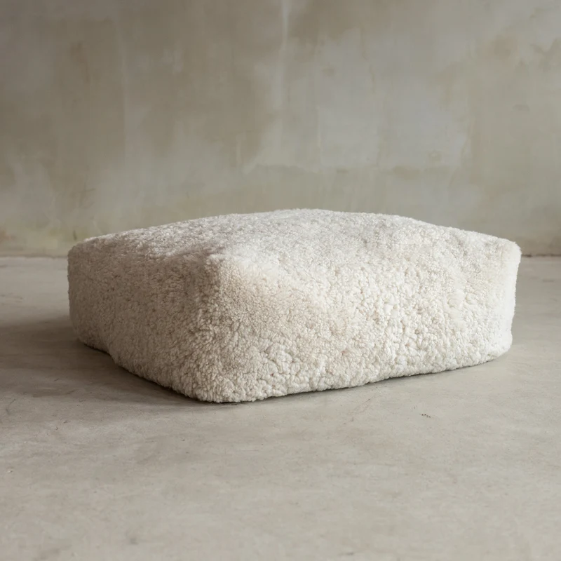 Coussin de sol peau de mouton bouclée blanc cassé